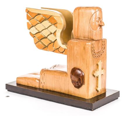 A kneeling bearded gilded winged figure with cross on chest.